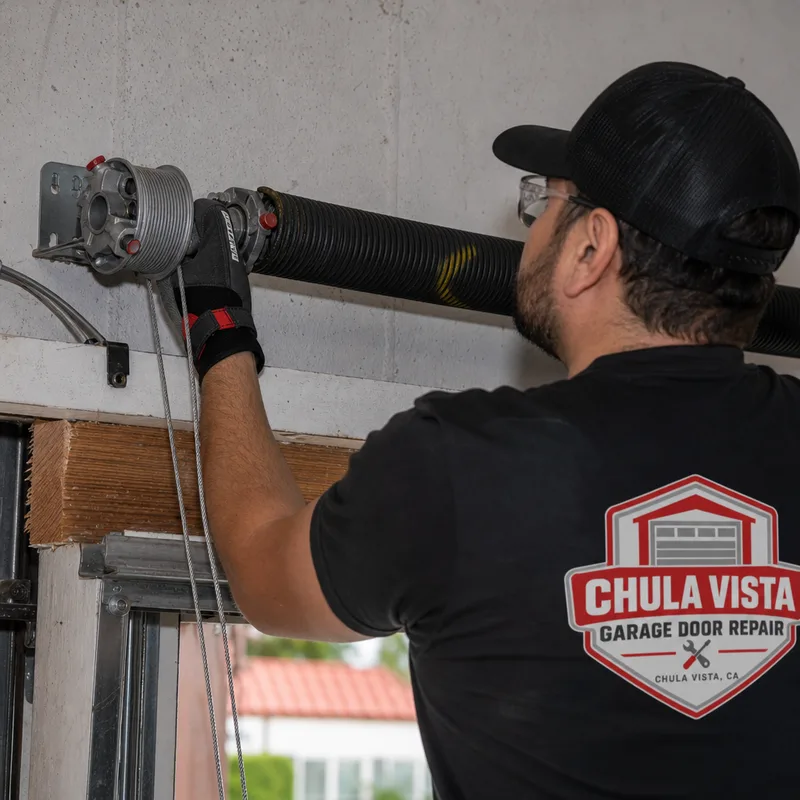 Commercial torsion spring, drums, and lift cables above an overhead door header